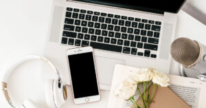 An image of laptop, phone, microphone and flowers all acting as the featured image for my best blogging online courses post